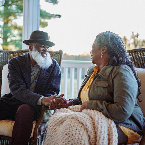 Senior couple relaxing on patio at sunset